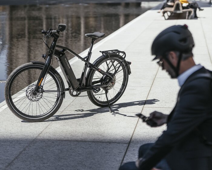 Business E-Bike Fahrer macht Pause und ist am Handy